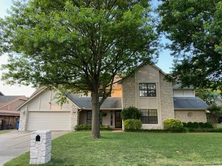Two story stucco and stone home with painted trim