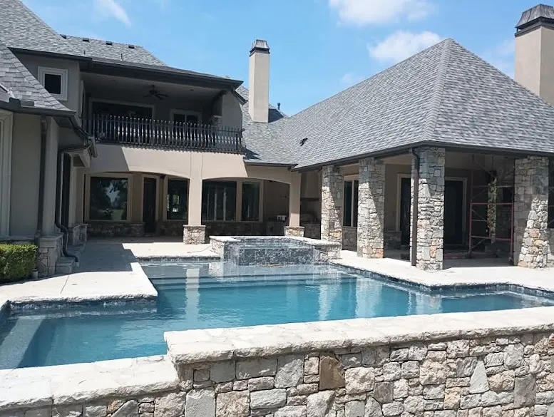 Stucco and stone luxury home with pool, exterior painted by David Woodall Painting near Broken Arrow, OK